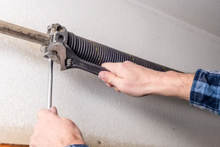 Garage door spring repair showing why DIY torsion spring work is risky