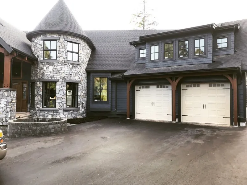 Carriage-style garage doors on stone and timber estate